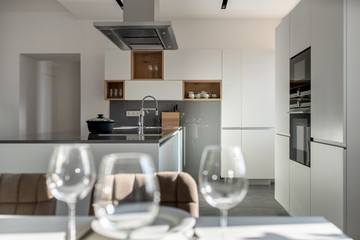 Sunny modern kitchen with white walls and tiled floor