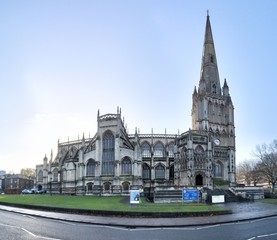 The Gothic and Reinassance Saint Mary Redcliffe Church, with typical bell tower and green lawn, during a sunny winter day in Bristol, United Kingdom