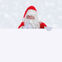 Santa Claus with blank sign making shhh sign  with a light silver background with snow flakes