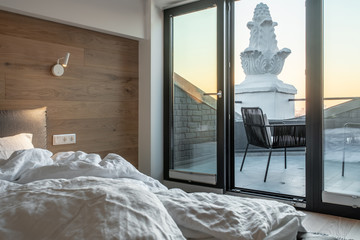 Sunny bedroom in modern style with exit to terrace