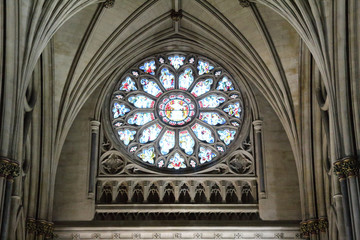 Obraz premium The main rose window under the pointed arch vault with colored stained glasses and Gothic decorations in the Bristol Cathedral, United Kingdom