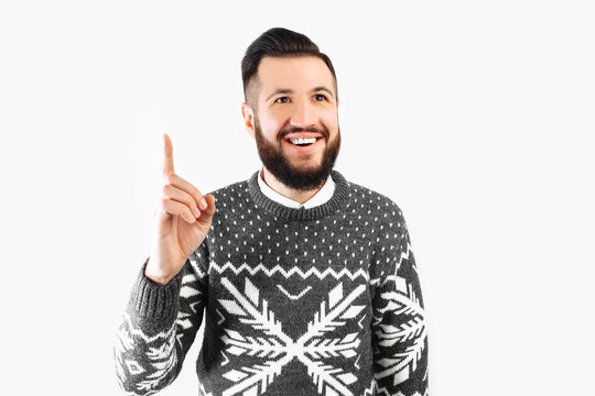 An image of a smiling man who has an idea. A handsome bearded guy in a sweater just came up with a great thought.