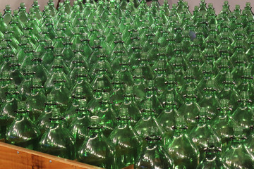 A series of green glass bottles all lined up in an attraction in the Gorsedd Gardens amusement park in Bristol, United Kingdom