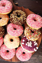 assorted donuts with chocolate frosted, pink glazed and sprinkles donuts