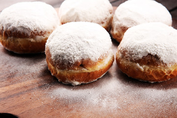 German donuts with jam and icing sugar. Carnival powdered sugar raised donuts