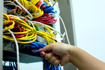 A hand holding LAN cord with Ethernet cables and Network switching hub LAN System Communication