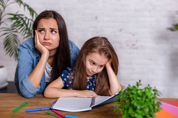 Mother becoming frustrated with daughter whilst doing homework sitting at the table at home in learning difficulties homework.