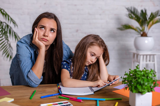 Mother becoming frustrated with daughter whilst doing homework sitting at the table at home in learning difficulties homework.