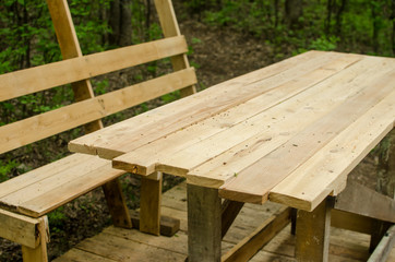 Fototapeta premium construction of wooden table and benches under canopy with in the forest