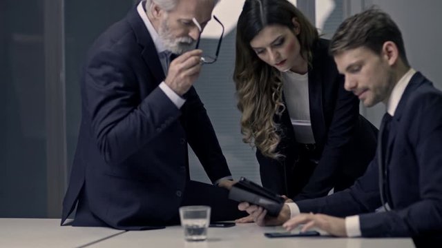 A couple of bussinessmen and bussines woman discussing an important topic