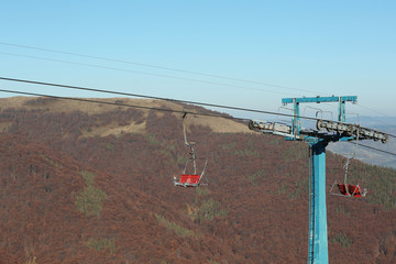 Fototapeta na wymiar Chairlift with comfortable seats at mountain resort