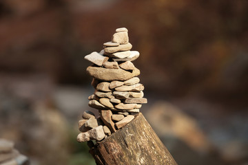 Tower of stones on tree stump in forest. Life balance