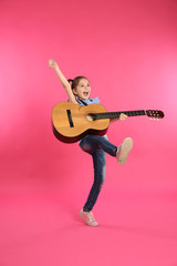 Obraz premium Cute little girl playing guitar on color background