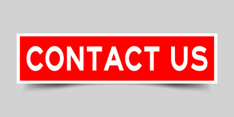 Square red color sticker with word contact us on gray background