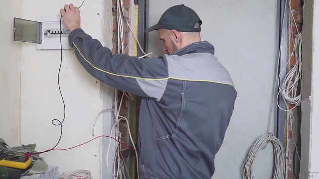 electrician at work measures the electric current