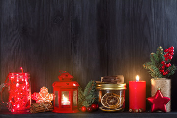 Christmas and New Year background with candle, light, decorations and gift box on wooden shelf. copy space