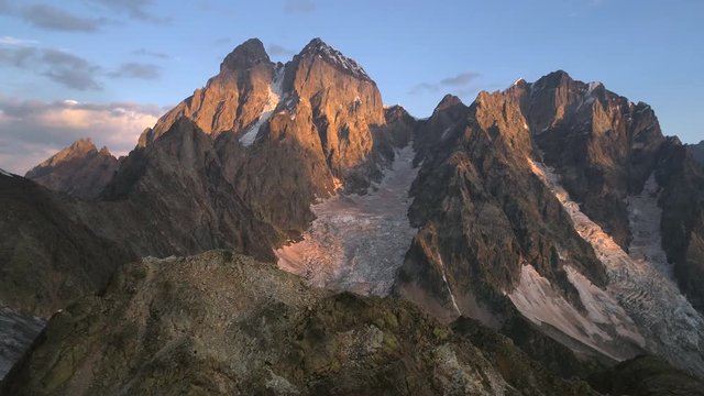 Aerial video of glacier in snowless mountains in the sunny evening, georgia