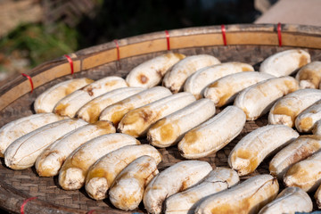Banana on threshing basket under direct sunlight to be dried bananas. Is food in Thailand is often made from Cultivated banana.