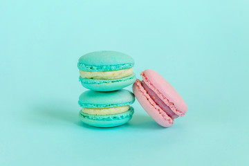 Sweet almond colorful pink blue macaron or macaroon dessert cake isolated on trendy blue pastel background. French sweet cookie. Minimal food bakery concept. Flat lay top view copy space