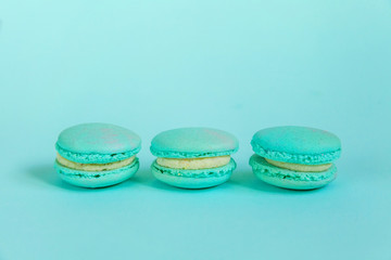 Sweet almond colorful unicorn blue macaron or macaroon dessert cake isolated on trendy blue pastel background. French sweet cookie. Minimal food bakery concept. Flat lay top view copy space