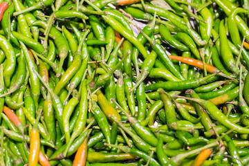 green and orange chili or peppers for sale in the Vegetable market.