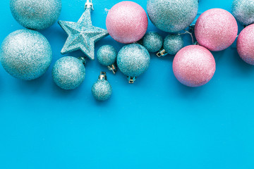 Toys for New Year tree 2019 background. Blue and pink balls and stars on blue background top view copy space border