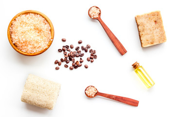 Aromatherapy and spa concept. Spa salt with coffee scent near soap, spa oil and loofah on white background top view