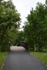 Fototapeta na wymiar Bike path with a bridge through the park