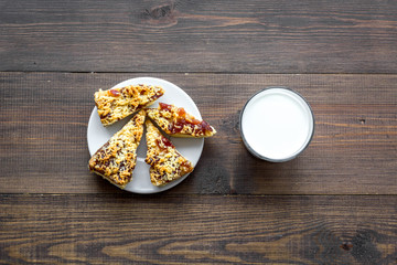Children tradition evening dessert. Milk and homemade cookies on dark wooden background top view