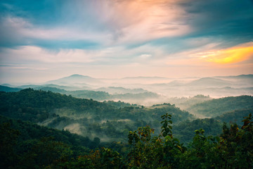 Obraz premium Foggy in the mountains with dramatic sky at sunrise