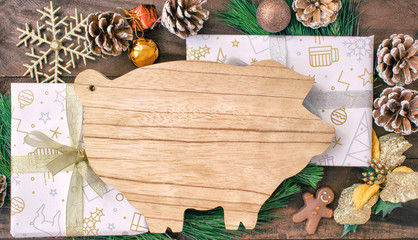 Christmas preparations, cutting board in the form of pigs, fir branches, cones and decorations. New Year of the pig on the Chinese calendar. With free text space.