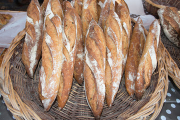 Traditional crusty French baguette bread in baskets shop market