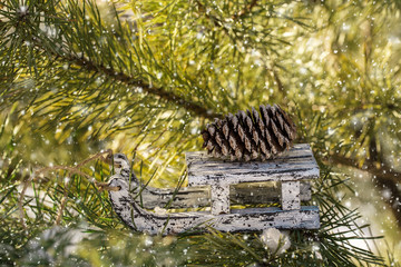 Christmas wooden toy sled on winter pine tree. 