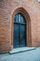 Medieval entrance door in a red brick wall