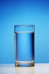A glass of clean water on a blue background.