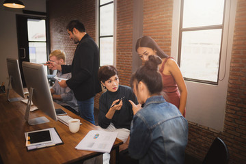 Group of young modern people in casual wear planning business strategy. Business team analyzing income charts and graphs.