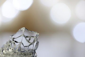A piece of glass with cracks on the background of a festive bokeh