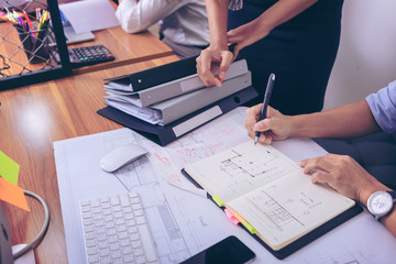Male manager putting his ideas and writing business plan at workplace,man holding pens and papers, making notes in documents, on the table in office. selective focus.