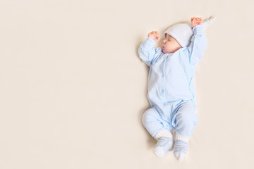 From above shot of lovely baby sleeping on soft bed at home, copy space