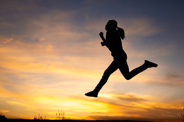 happiness, freedom, motion and people concept - smiling young woman jumping in air sunset background