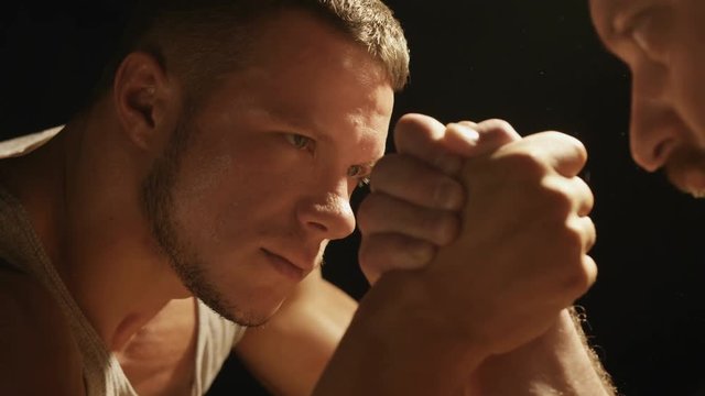 Two strong muscular men engaged in armwrestling