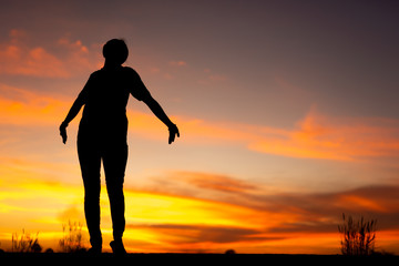 Young woman relaxing in winter sunset sky outdoor.