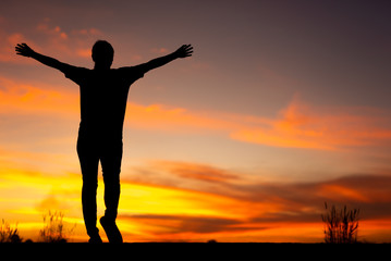 Fototapeta premium Young woman relaxing in winter sunset sky outdoor.