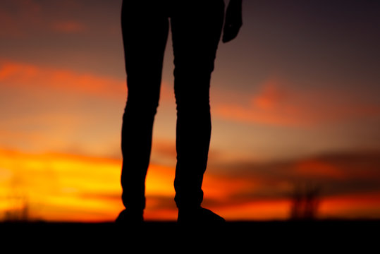 Silhouette of sad and depressed women walking at walkway of park with sunset