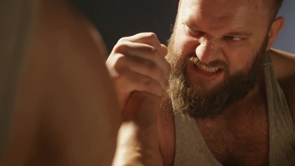 Two strong muscular men engaged in armwrestling