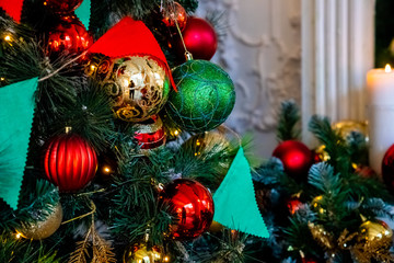 Magically decorated Christmas Tree with balls, ribbons and garlands on a blurred shiny, fairy and sparkling background.Decorated Christmas tree. Bright decorations for the New Year. Christmas