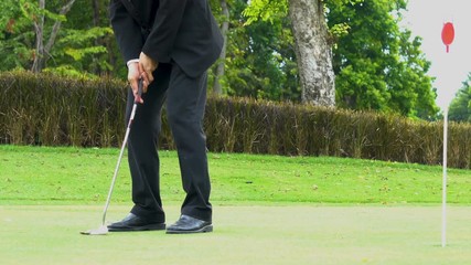 Business guy playing golf.