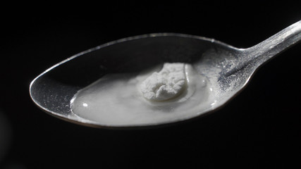 Close up of person cooking heroin using lighter