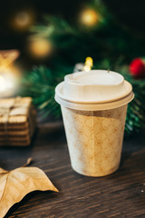 Coffee in paper cup with blurred festive background
