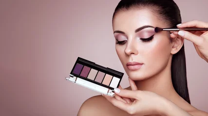Poster Makeup Artist applies Eye Shadow. Beautiful Woman Face. Perfect Makeup. Make-up detail. Beauty Girl with Perfect Skin. Nails and Manicure. Eye Shadow Palette © Oleg Gekman